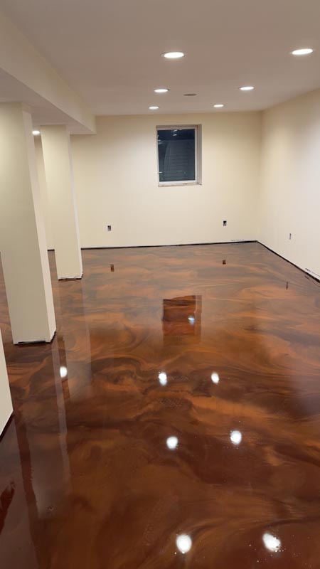 Residential basement with glossy copper and brown metallic epoxy floor and recessed lighting