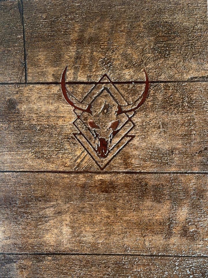 Close-up of wood-look stamped concrete with engraved custom logo