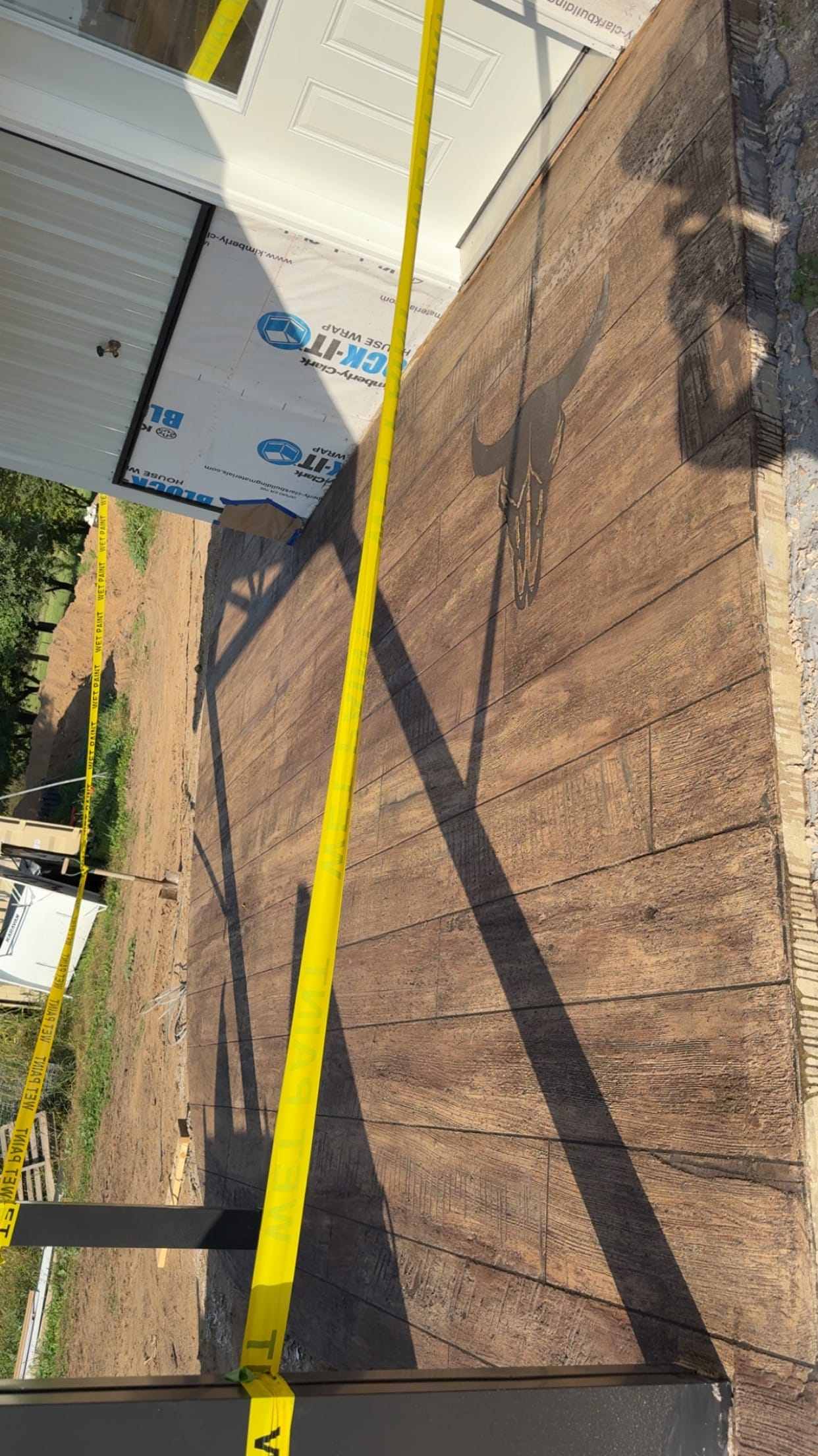 Outdoor wood-plank stamped concrete slab with engraved custom logo
