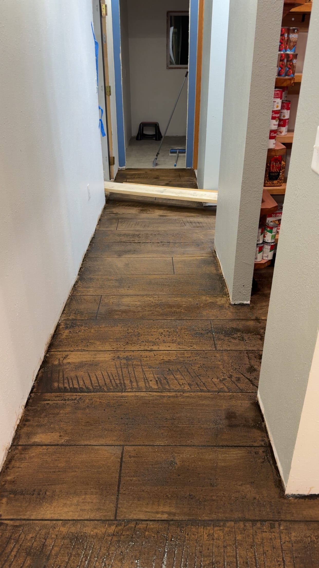 Interior hallway with dark wood-plank stamped stained concrete floor